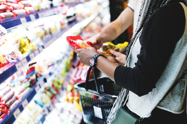 couple purchasing processed foods at a grocery store.