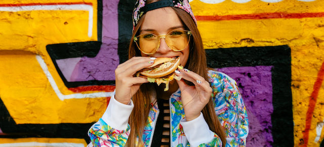 woman eating a hamburger with vegan meat.