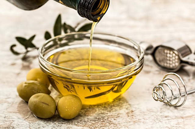 olive oil being poured in a bowl, a good food on keto.