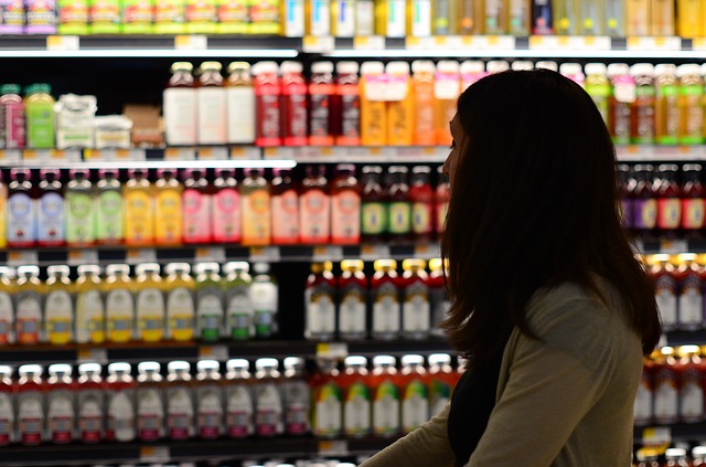 woman looking at all the fruity overpriced drinks in a grocery store.