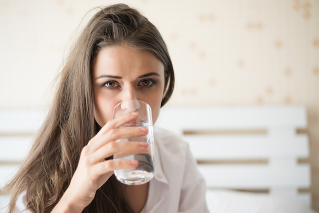 woman drinking a glass of water. 
