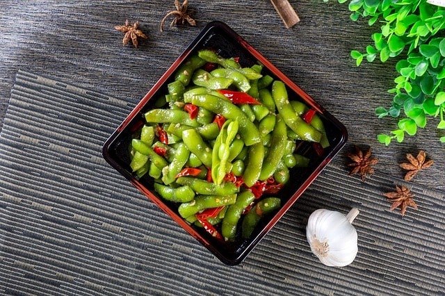 A bowl of edamame with garnishes. 